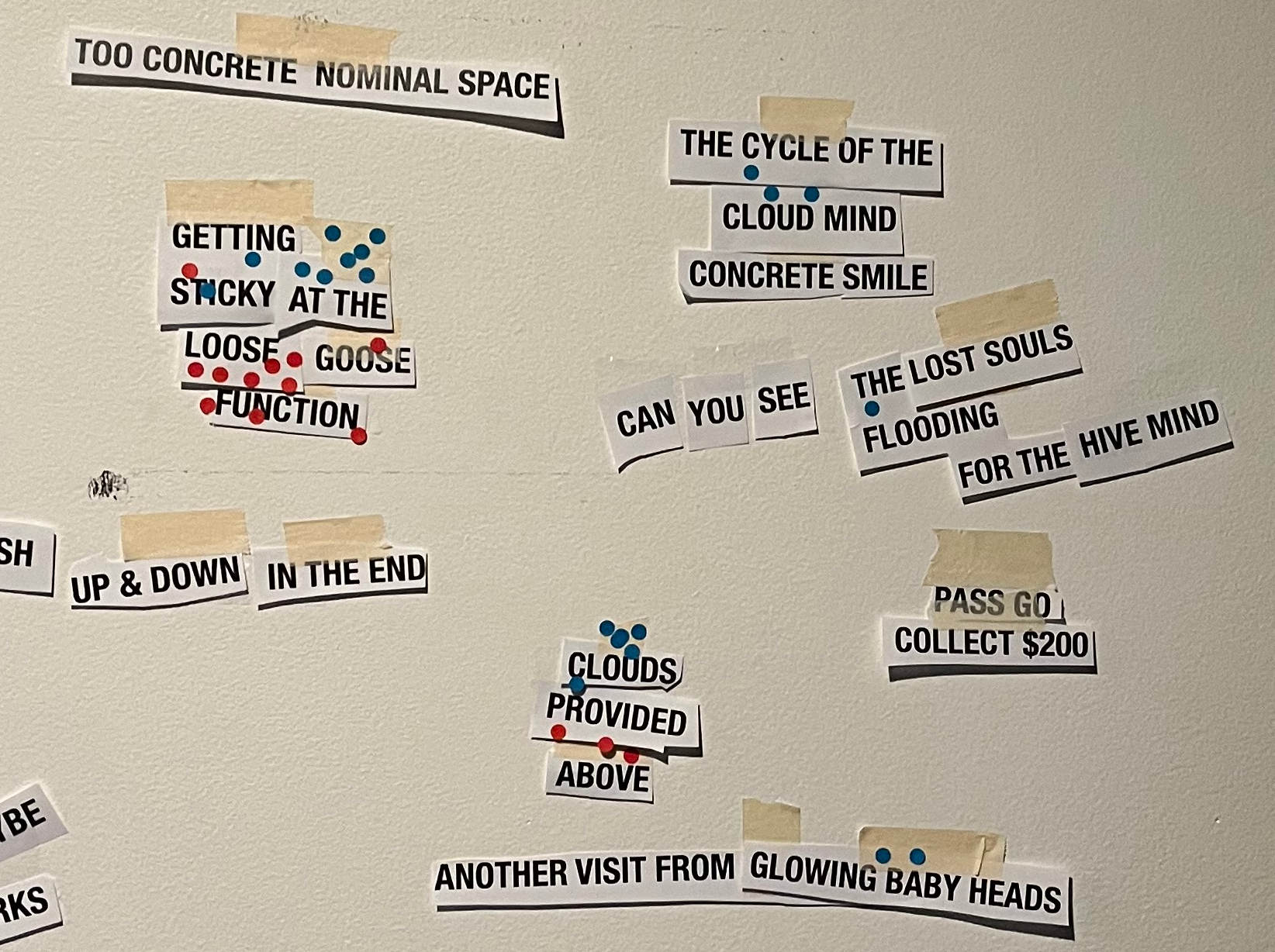 Paper cut-out words taped to a wall reading 'Getting Sticky at the Loose Goose Function' among other phrases